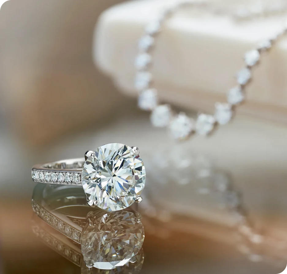 Кольцо с бриллиантом на фоне ожерелья